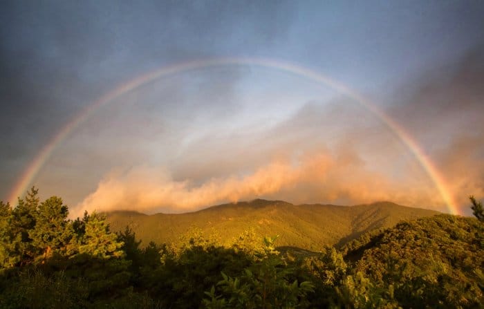 Un hermoso paisaje con un arco iris completo arriba: consejos para la fotografía del arco iris