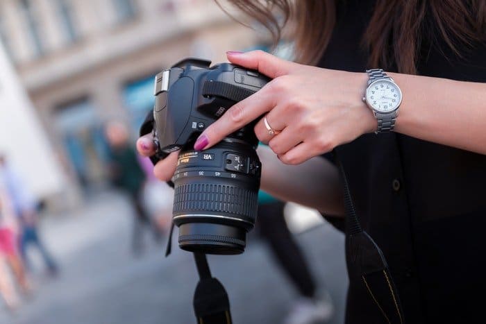 Foto de una mujer sosteniendo una cámara réflex digital