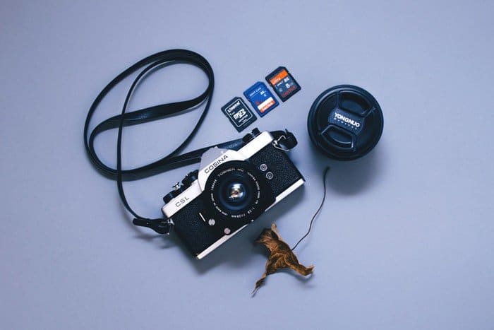 Foto de una cámara y tres tipos diferentes de tarjetas de memoria.