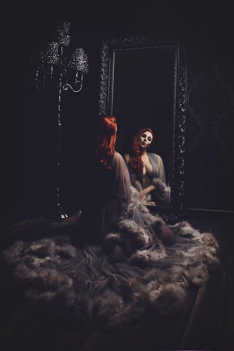Fotografía de tocador de autorretrato atmosférico de una modelo femenina posando en un interior de estilo gótico
