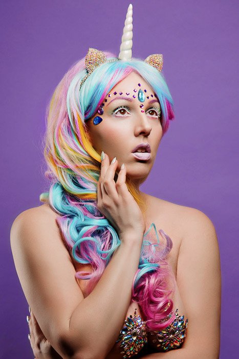 Autorretrato creativo fotografía de tocador de una modelo femenina en traje de unicornio