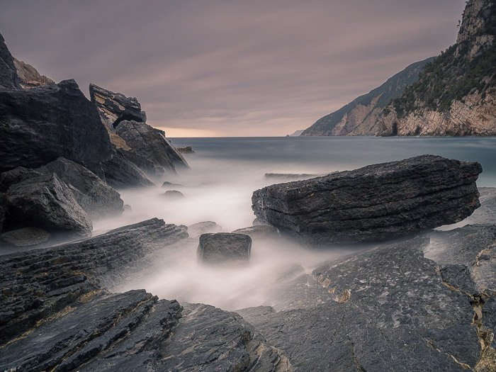 Impresionante toma de larga exposición de un paisaje marino costero rocoso en Porto Venere