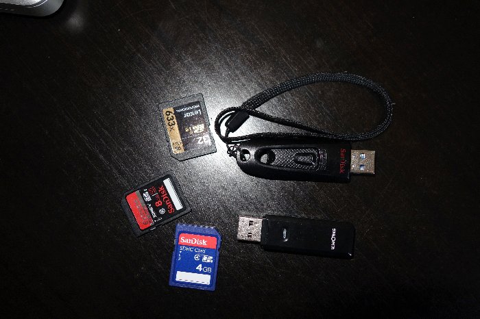 Fotografía cenital de memorias USB y tarjetas SD para fotografía de viajes, la mejor manera de hacer copias de seguridad de las fotos en una mesa negra