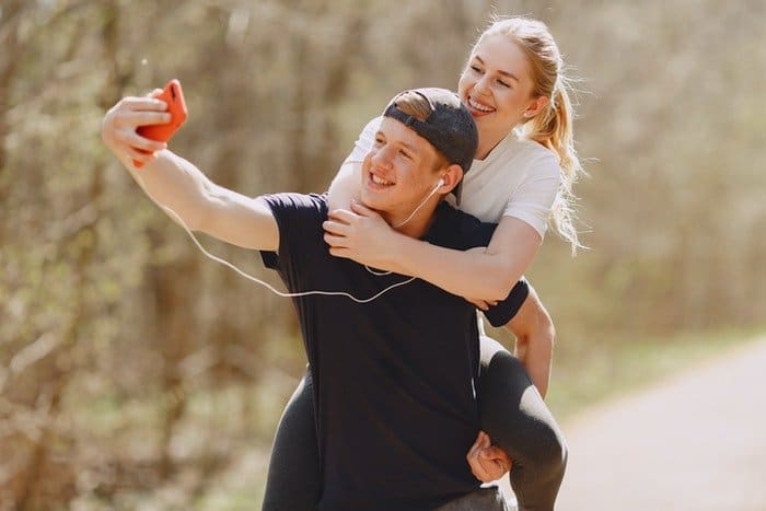 Un joven se toma un selfie con su novia a cuestas