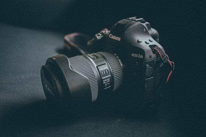 Cerca de una cámara réflex digital Canon sobre fondo negro: el mejor lugar para vender equipos de cámara usados