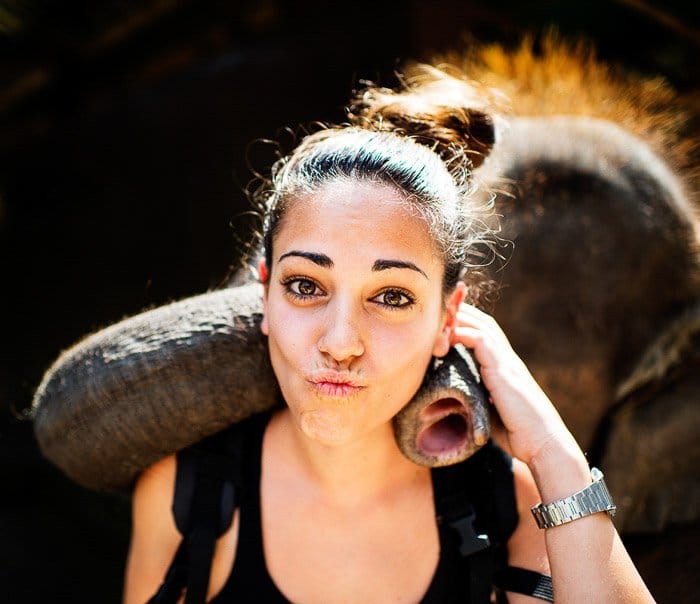 Un retrato ligero de llanta de una turista posando con un elefante