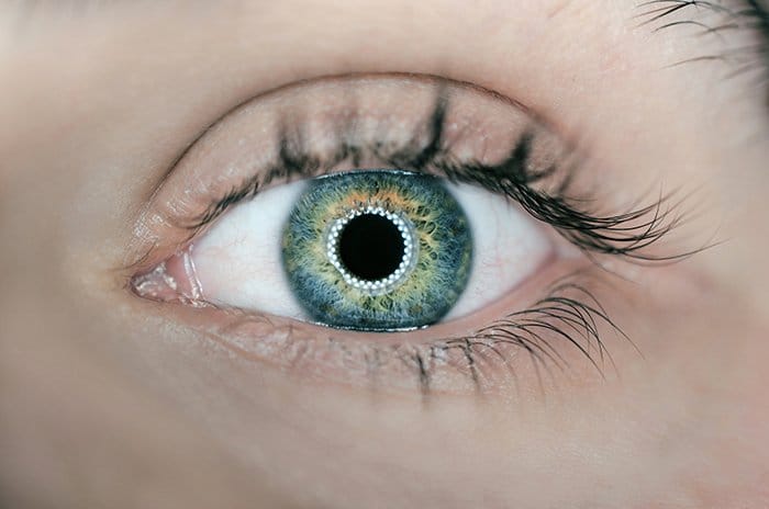 Un primer plano impresionante de un ojo verde de personas fotografiado con luz de anillo