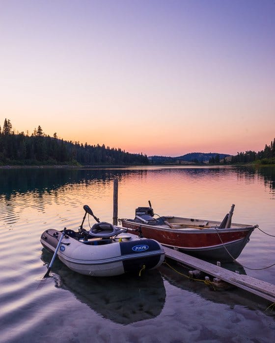Una fotografía de viaje por carretera tomada de dos pequeñas embarcaciones atadas en un lago al atardecer