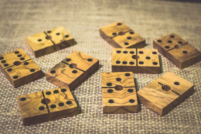 Cerca de nueve fichas de dominó de madera sobre mesa marrón