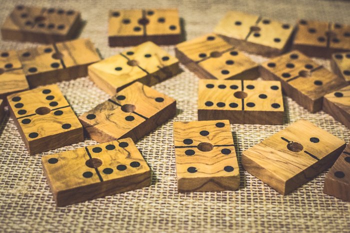 Cerca de varias fichas de dominó de madera sobre una mesa marrón.