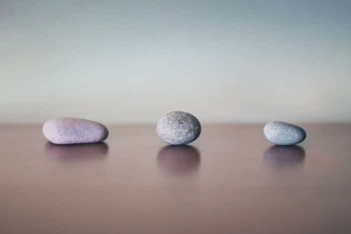 Tres piedras grises sobre la superficie de la madera.