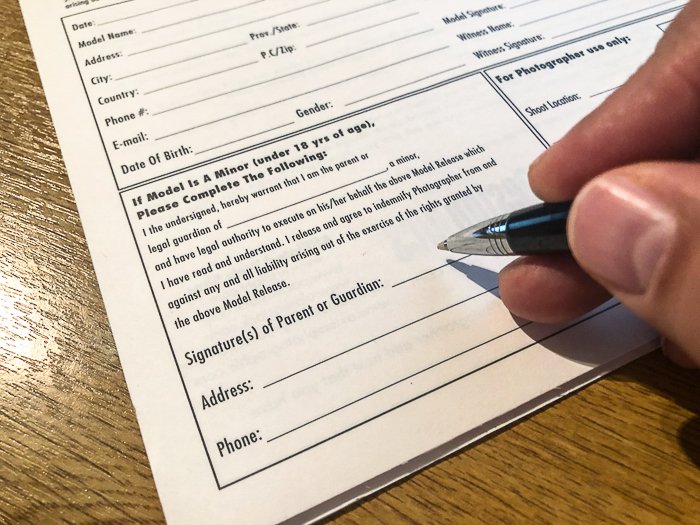Cerrar una foto de una mano sosteniendo un bolígrafo cerca de un formulario para firmar - Cómo tomar fotografías de archivo que venden