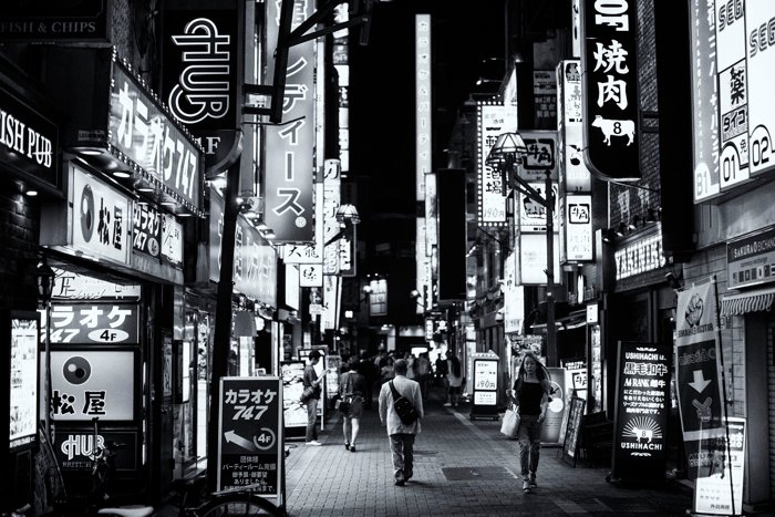 Una foto en blanco y negro de una concurrida escena callejera en Tokio