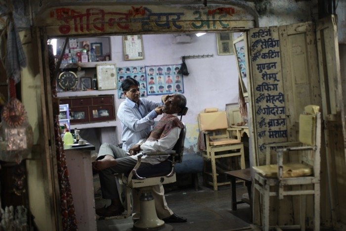 Una foto sincera de un peluquero afeitando a un cliente: configuración de la cámara de fotografía callejera