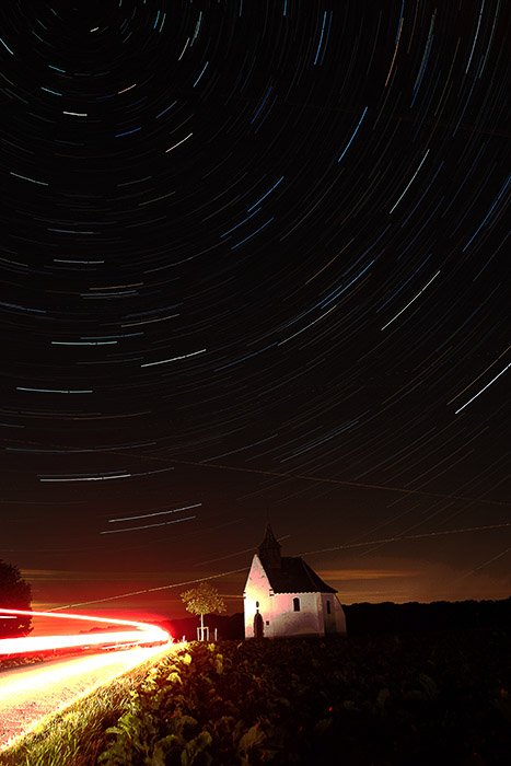 Imagen inicial de un paisaje nocturno con impresionantes senderos de estrellas