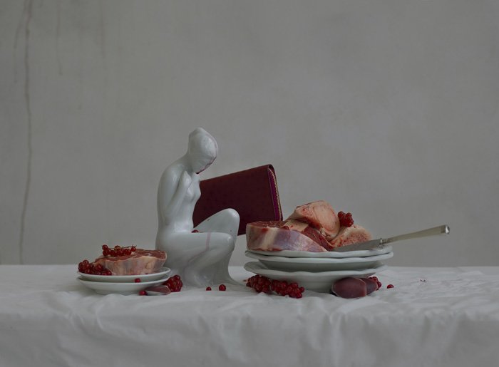 Foto de bodegón abstracto con una pequeña escultura y dos platos de comida