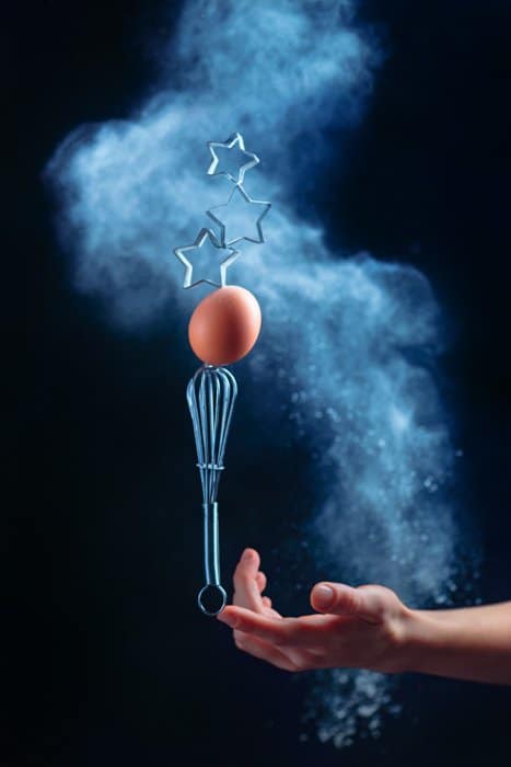 Una foto de bodegón genial con utensilios de cocina voladores y nubes de harina: fotografía creativa de bodegones