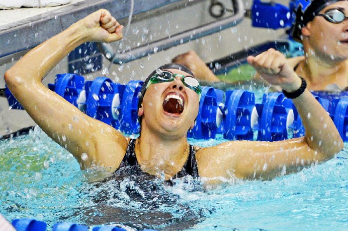 Una toma de acción de una nadadora celebrando la victoria después de una carrera: cómo tomar fotografías de natación