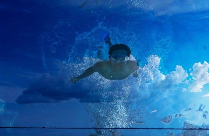 Un hombre nadando superpuesto con una foto de nubes: cómo usar superponer 