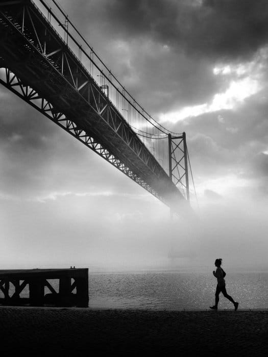 Imagen en blanco y negro de un corredor con el brumoso Golden Gate en el fondo