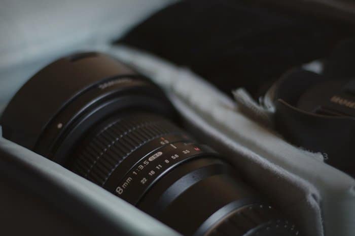 Un primer plano de la lente de una cámara en una bolsa de la cámara: fotografía con flash o con luz estroboscópica