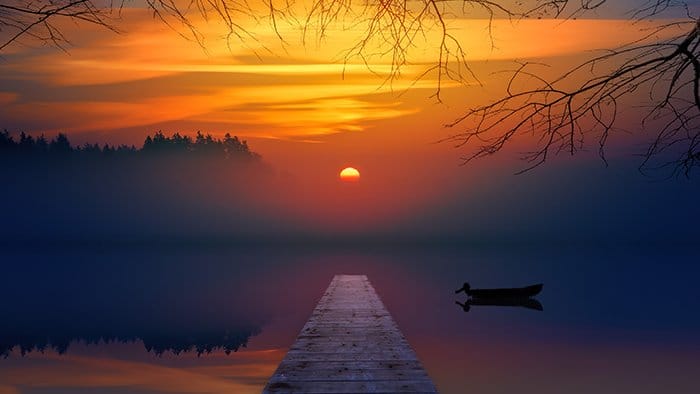Una hermosa puesta de sol sobre un lago brumoso.