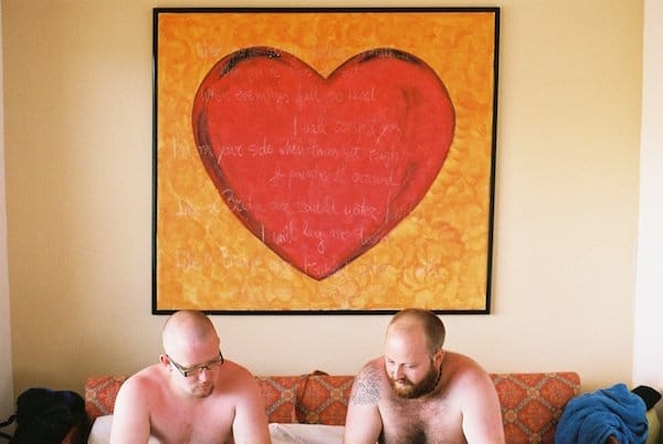 Dos hombres se sientan bajo un enorme corazón rojo - Luz de ventana para retratos