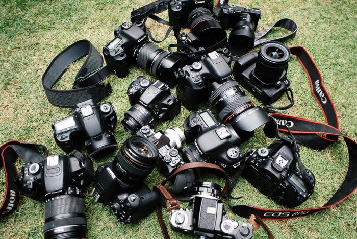 Fotografía cenital de cámaras DSLR sobre césped- vender equipo de cámara