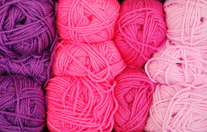 Líneas de ovillos de lana de color rosa y violeta - usando colores vibrantes en la fotografía