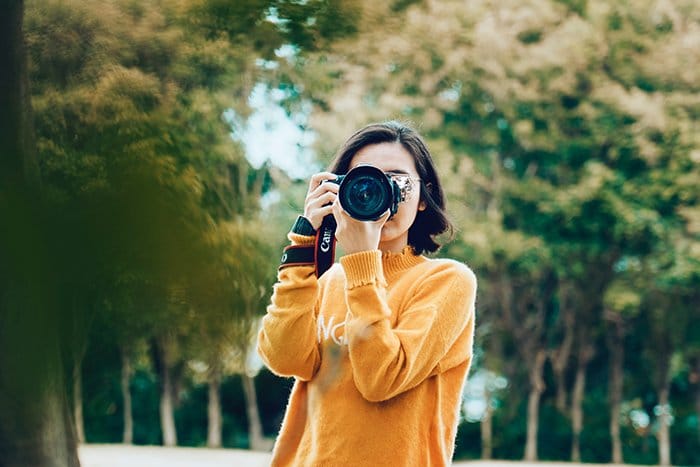 Una mujer tomando una foto frente a la cámara.