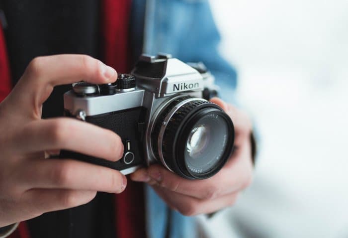 Cerca de las manos de una persona sostenga una cámara Nikon