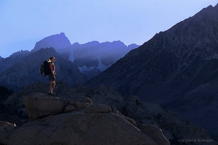 Una fotógrafa de aventuras de pie sobre rocas en Buttermilks, Sierra Nevada, California