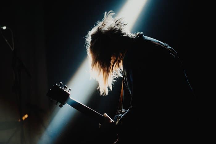 Una imagen de la fotografía de un concierto de un guitarrista en el escenario.