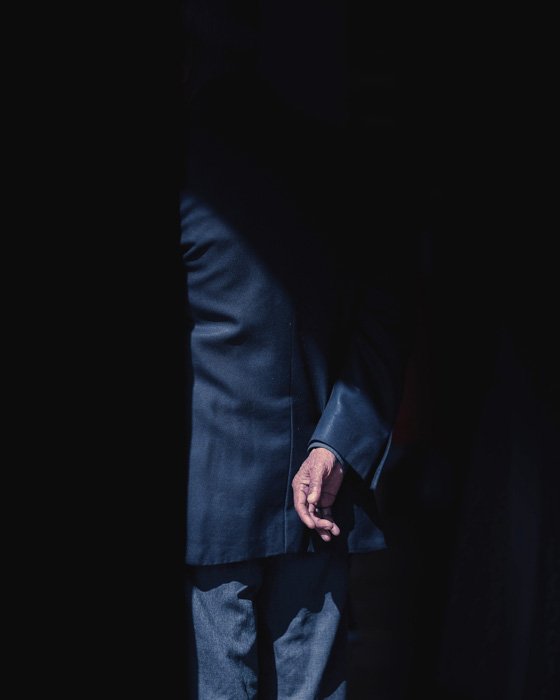 Una imagen creativa de un hombre en un traje de negocios, la mayor parte de su cuerpo cubierto de sombras
