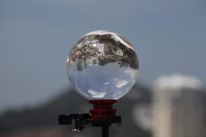 un lensball sobre un trípode, que refleja un paisaje urbano en expansión