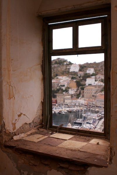 Foto de un puerto griego enmarcado por una ventana vieja