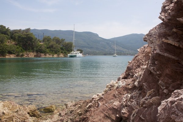 Línea de mar con montañas al fondo y un par de yates