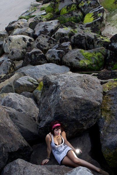 niña sentada entre enormes rocas en la parte inferior del marco