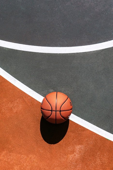 Genial composición de una pelota de baloncesto apoyada en una cancha - consejos para fotografía de baloncesto