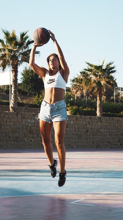 un retrato de una jugadora de baloncesto saltando con la pelota - sesión de fotos de baloncesto 