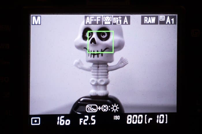 Cerca de ajustar los modos de enfoque automático en una cámara mientras se enfoca en una figura de plástico de un esqueleto
