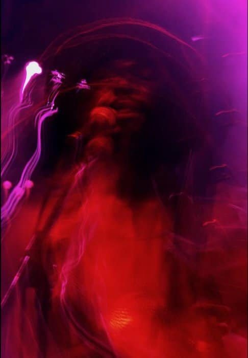 foto borrosa con estelas de luz roja, violeta y rosa por movimiento intencional de la cámara