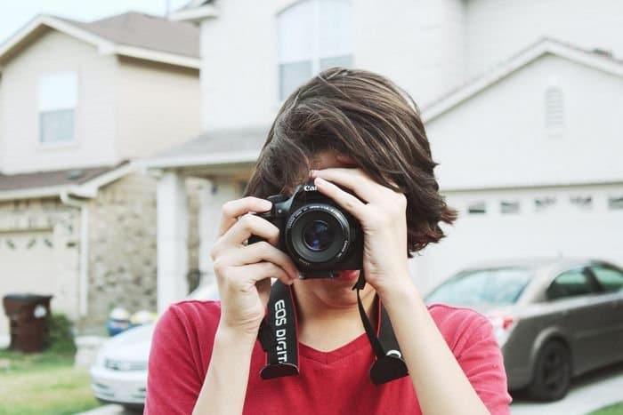 foto de un chico tomando una foto con una cámara réflex digital 