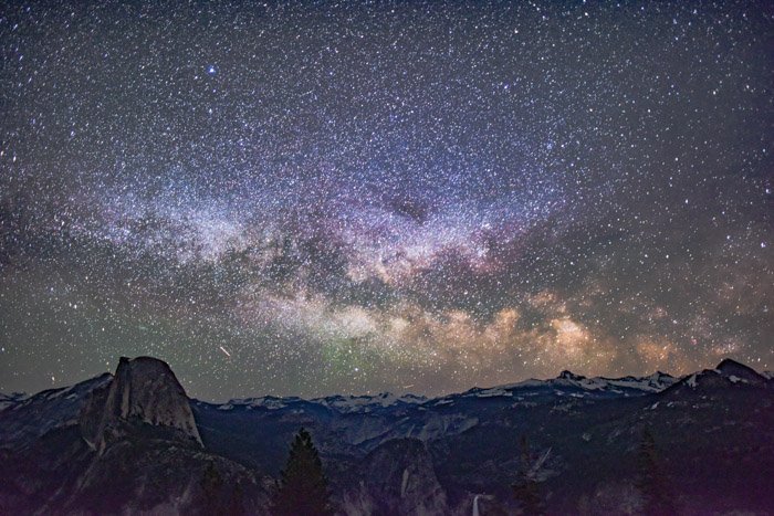 Magnífica foto del cielo nocturno plagado de comienza sobre un hermoso paisaje montañoso
