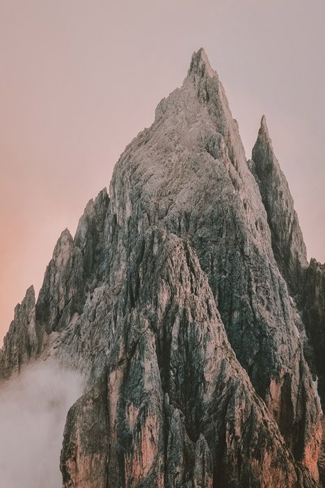 la cima de una montaña rocosa contra un cielo rosado suave - impresionantes fotos de paisajes
