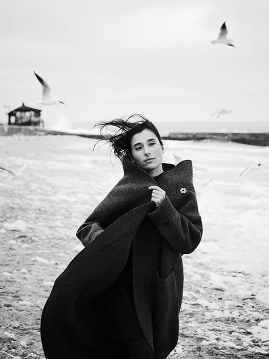 Un retrato monótono de una modelo femenina caminando en una playa - principios de la hermosa fotografía