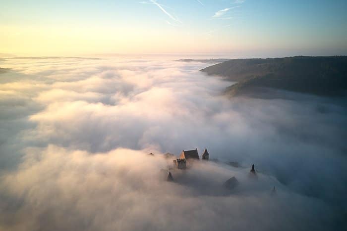 foto aérea de un castillo sumergido en la niebla - principios de la fotografía hermosa