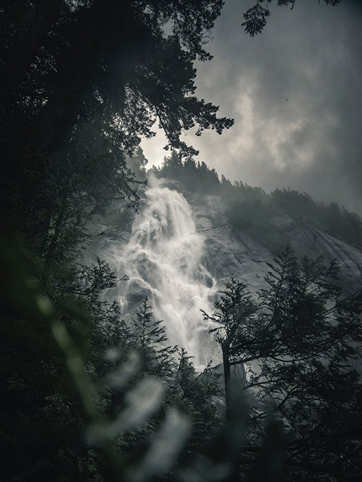 Foto atmosférica de una cascada que fluye en un día nublado - principios de la fotografía hermosa