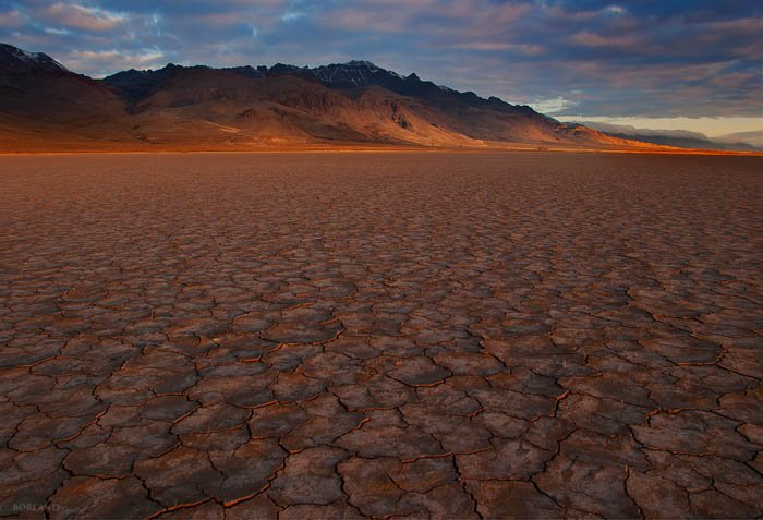 Fotografía del desierto que muestra el uso de patrones en primer plano para atraer la atención del espectador hacia las montañas en el horizonte.