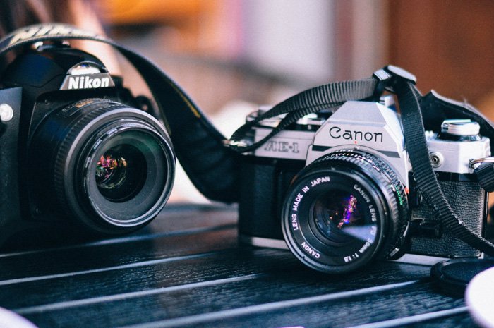 Una cámara fotográfica de película Canon y Nikon de 35 mm sobre una mesa